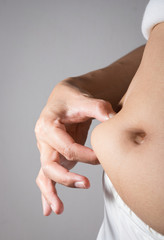 Woman measuring belly fat.