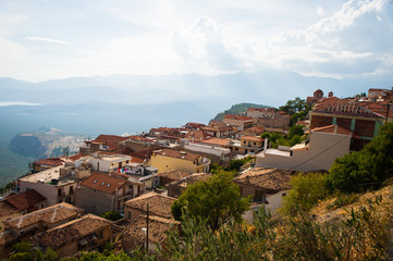 Obraz premium Greece, Delphi, August 2016, beautiful sun shining through the clouds lightning just part of hill. Panorama from one of city restaurants