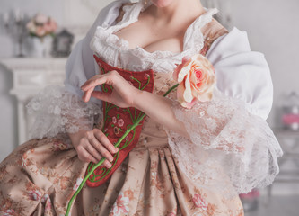 Beautiful woman in medieval dress holding rose