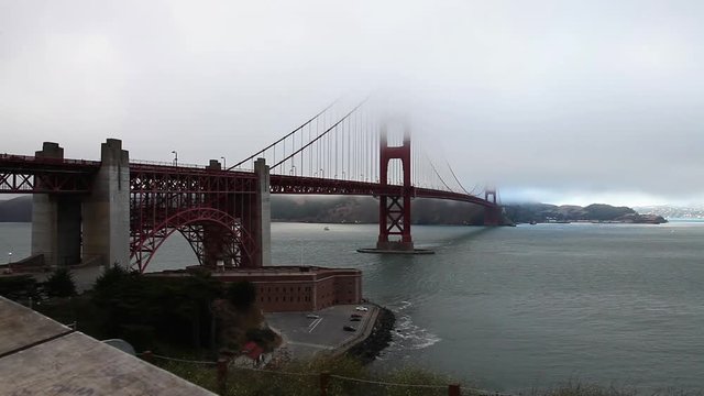 Symbol of San Francisco the Golden Gate Bridge in the fog. Fort Point at dusk, San Francisco Bay, California, United States.