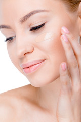 Obraz na płótnie Canvas woman with foundation cream on face