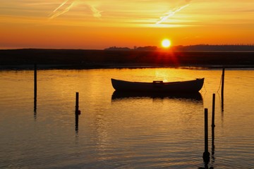 Obraz na płótnie Canvas The dinghy embraces the sunset in February