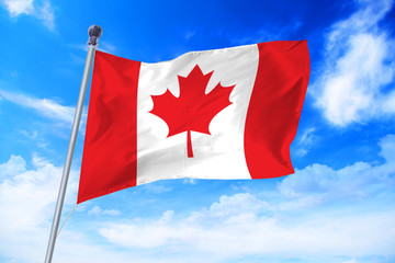 Flag of Canada developing against a clear blue sky