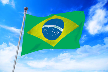Flag of Brazil developing against a clear blue sky