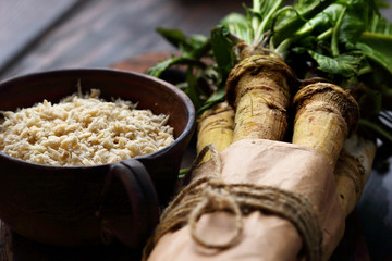 raw horseradish roots on wooden background. horseradish with leaves.closeup. selective focus
