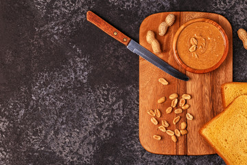 Bowl of peanut butter on wooden board.