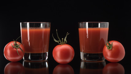 Still life with tomato juice in glass on black background