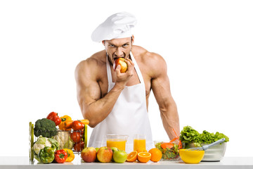 Man bodybuilder in white toque blanche and cook protective apron eat apple