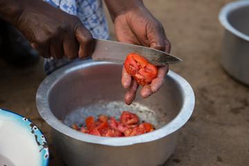 Cutting tomatoes for dinner in a Malawian Village, Africa