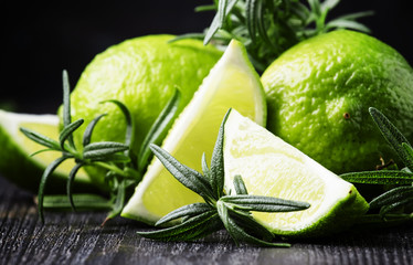 Lime and rosemary, black background, selective focus