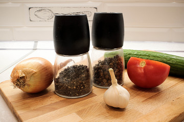 Овощи огурец, помидор, лук и чеснок на кухонной деревянной доске