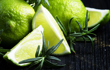 Lime and rosemary, black background, selective focus