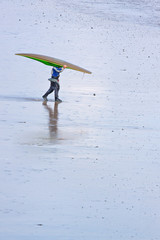 Obraz na płótnie Canvas A lone kayaker making his way across a North Devon beach