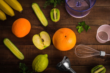 Blender and fruits on wooden background