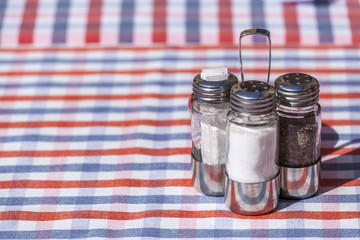 Salt, pepper and toothpick set over an outdoor restaurant table