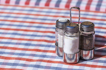Salt, pepper and toothpick set over an outdoor restaurant table