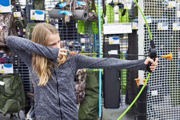 Girl is trying children's bow in sport store