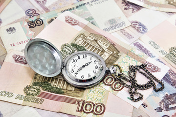 Pocket watch against the background of Russian money. Time to pay taxes