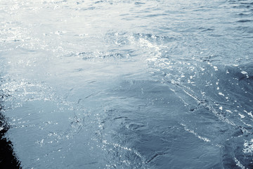 Water surface with ripples and sunlight reflections