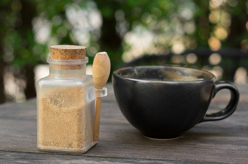 Sugar bottle with hot coffee cup.