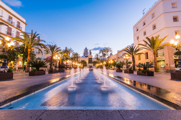 Illuminated square in Cadiz with fountains at twilight