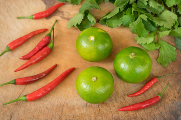 Lemons and red chili on wood board.