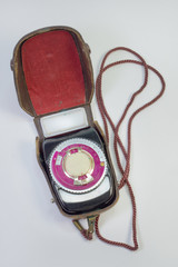old analog light meter in leather case on strap