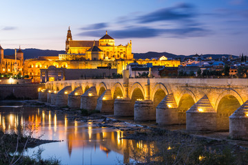 Fototapeta na wymiar Illuminated Roman Bridge and Mosque-Cathedral at twilight in Cordoba, Spain