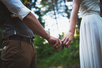 Bride and groom holding hands with rings