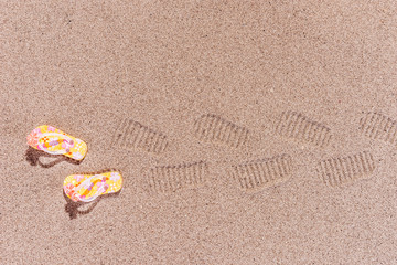 Spuren von Flip Flops am Sandstrand
