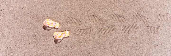 Spuren von Flip Flops am Sandstrand