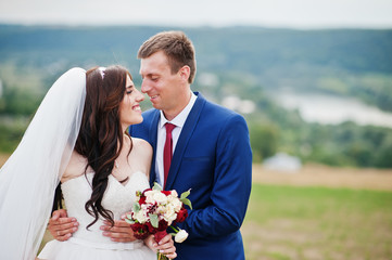 Wedding couple in love stay at beautiful landscape with river on background.