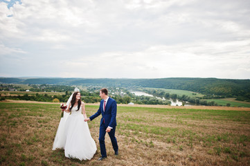 Wedding couple in love stay at beautiful landscape with river on background.