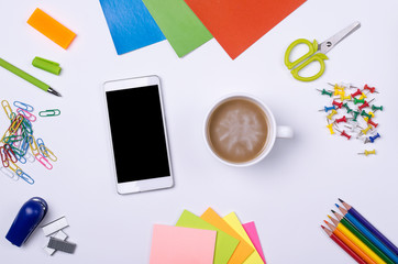 School and office supplies, smartphone and cup of coffee on a white background.