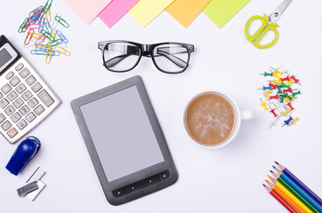 School and office supplies, tablet and glasses on a white background.