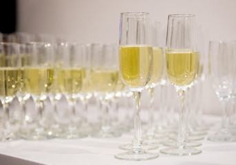Champagne pour into glasses on the table