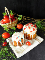 Easter cake surrounded by coloured eggs and spring green. Easter cake is decorated with glazing and confectionery