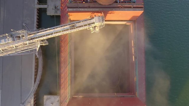 Aerial view of big grain elevators on the sea. Loading of grain on a ship. Port. Cargo ship