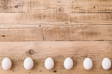 Top view on white eggs on a wooden background. Easter festive background. Flat lay.
