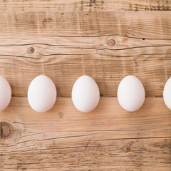 Top view on white eggs on a wooden background. Easter festive background. Flat lay.
