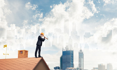 Engineer man standing on roof and looking in spyglass. Mixed med