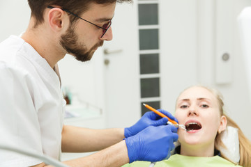 Young male dentist is treating a woman's teeth
