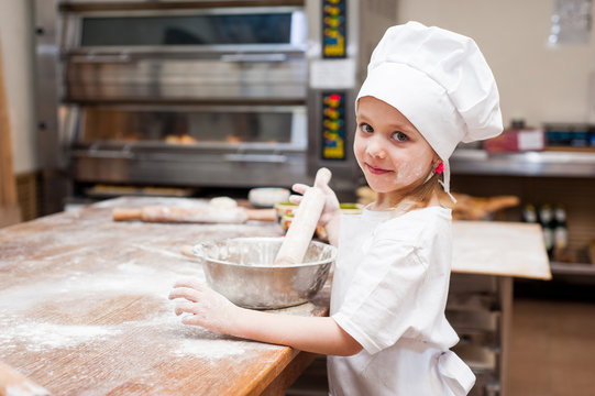 Portrait of a little chef cooking girl