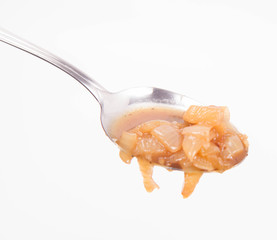 Onion soup being eaten with a spoon on a white background