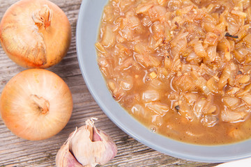 Onion soup being eaten with a spoon on a white background