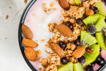 Healthy diet breakfast: smoothies bowl, with yogurt, fresh blueberries (black currant), kiwi,...