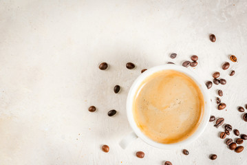 Morning. Food background. Grains of coffee, a cup of freshly brewed coffee and brown cane sugar on a white stone table. Copy space top view