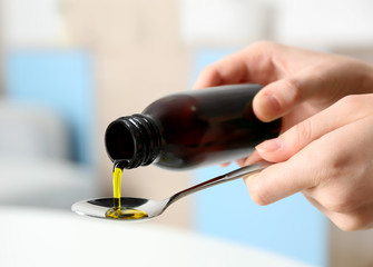 Pouring syrup in spoon, closeup