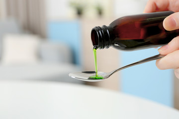 Pouring syrup in spoon, closeup