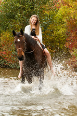 Fototapeta na wymiar Hübsches Mädchen mit Pferd im See
